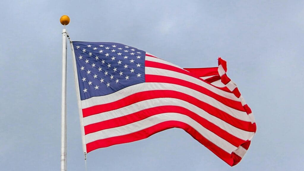 U.S. flag waving against cloudy sky, representing trade relations and tariff policies with Vietnam