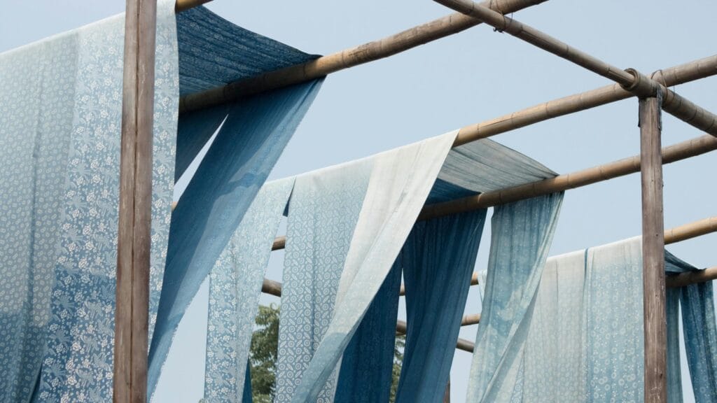 Blue patterned fabrics hanging outdoors, symbolizing Vietnam’s textile heritage and garment industry strength