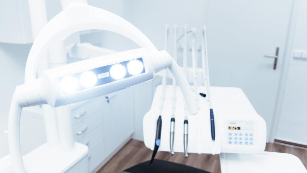 Modern dental examination room with LED overhead light, dental chair, and advanced equipment