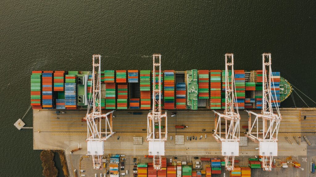 Aerial view of cargo ship and cranes at port, symbolizing Vietnam’s export order flow and logistics operations